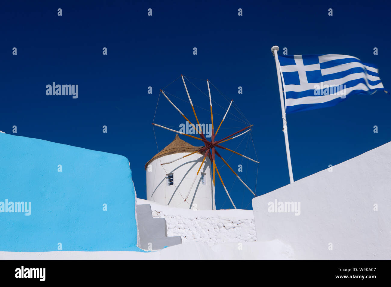 Église, moulin et drapeau grec, Santorini, Cyclades, îles grecques, Grèce, Europe Banque D'Images