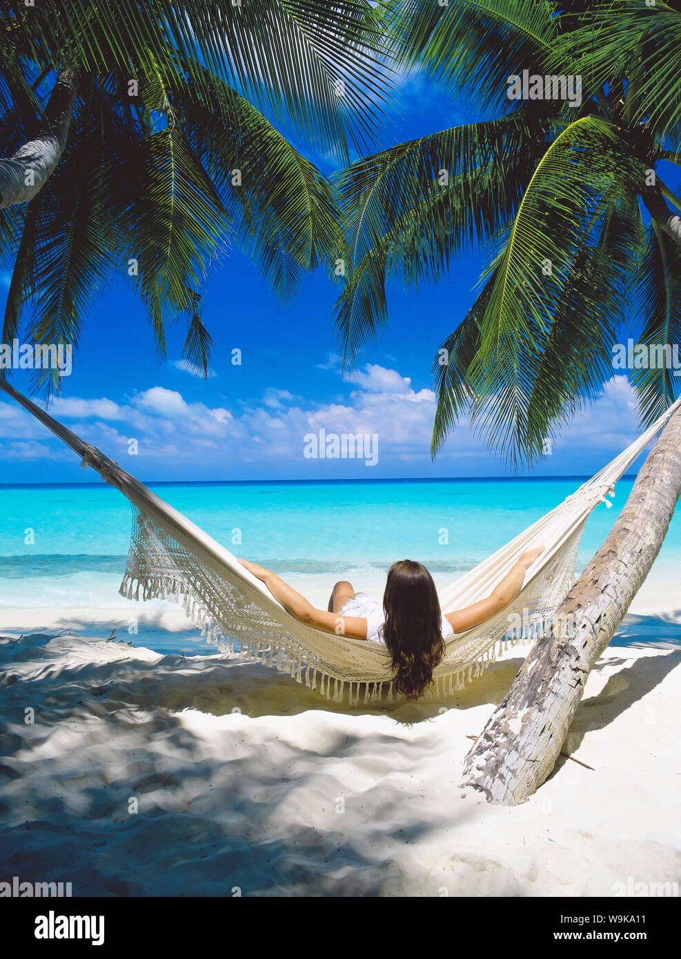 Femme assise en hamac sur la plage, Maldives, océan Indien, Asie Banque D'Images