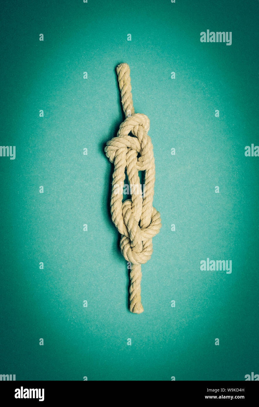 Nautical knot avec corde blanche sur fond bleu turquoise. Couverture du livre potentiel. Banque D'Images