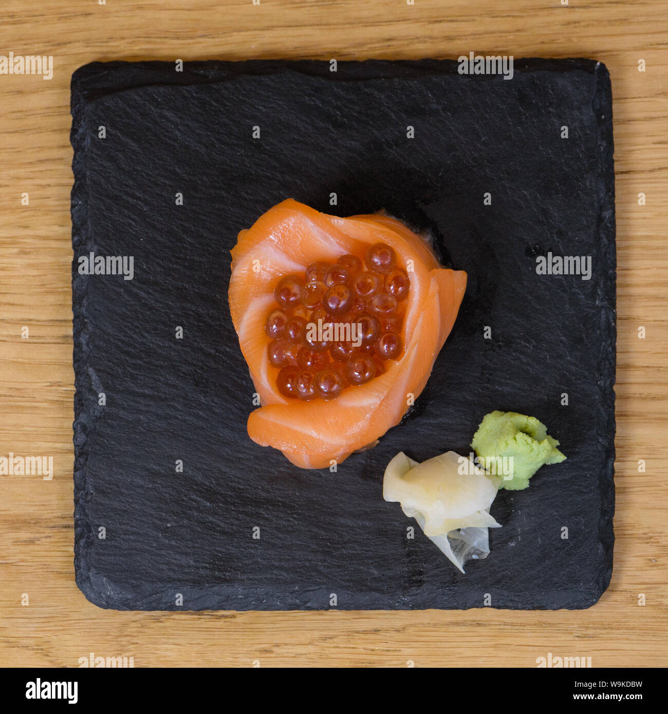 Composition de la nourriture pour poissons, les filets de saumon monté sous la forme d'une tasse, farcie de caviar, servi de plaque sur une dalle d'ardoise, garni d'un gingembre Banque D'Images