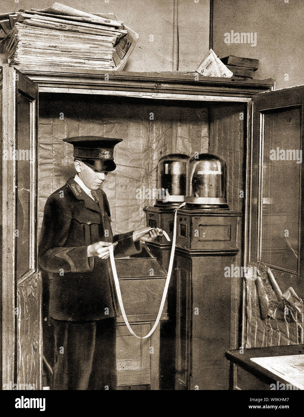 C1940's -un garçon en uniforme à l'ancien télégraphe News Chronicle Journal national (propriété de la famille Cadbury UK) réception d'un télégramme news sur la bande qu'il va ensuite coller sur papier et passer à l'éditeur de presse. Le papier a cessé de paraître le 17 octobre 1960 et ont été regroupés avec le Daily Mail Banque D'Images