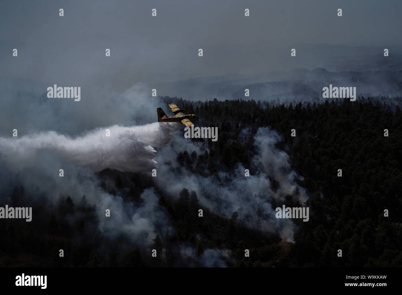 Athènes, Grèce. 14 août 2019. Les pulvérisations d'un avion sur un front du feu près de Stavros village, sur l'île d'Eubée, Grèce, le 14 août 2019. Dans le contexte des efforts pour éteindre un feu destructeur, Premier Ministre grec Kyriakos Mitsotakis le mercredi a appelé à renforcer la coopération entre les pays de l'Union européenne (UE) membres pour lutter contre les catastrophes naturelles. Il a fait l'appel au cours d'une visite à l'île de Evia frappés par l'incendie. Source : Xinhua/Alamy Live News Banque D'Images