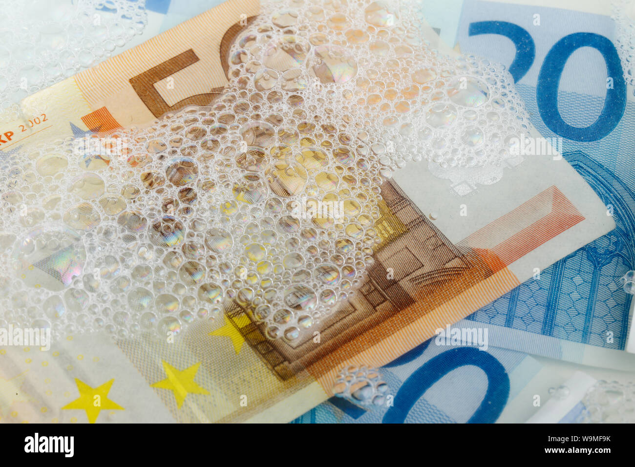 Image plein cadre des billets en euros dans diverses confessions dans l'eau savonneuse. Banque D'Images