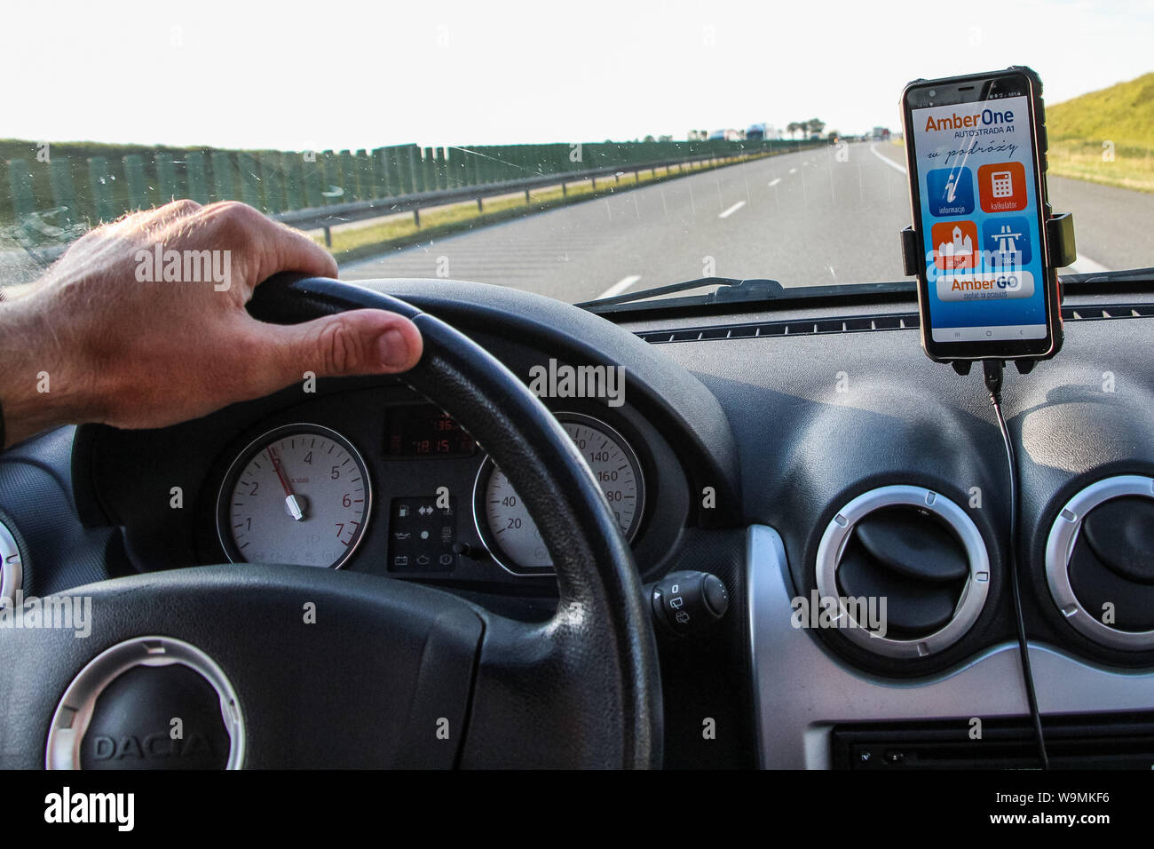 Rusocin, Pologne. 13th, 2019 Août pilote dans une voiture Dacia Sandero avec AmberGo application fonctionnant sur un smartphone est vu. AmberGO pleinement lancé par la compagnie de transport de Gdansk (GTC) à la fin du mois de juillet 2019 est un système de paiement automatique basé sur le système de reconnaissance automatique des plaques d', nécessitant l'installation d'une application mobile et la connexion de la carte de paiement. Le système a été mis en œuvre par l'Arcus Infrastructure Partners. © Vadim Pacajev / Alamy Live News Banque D'Images