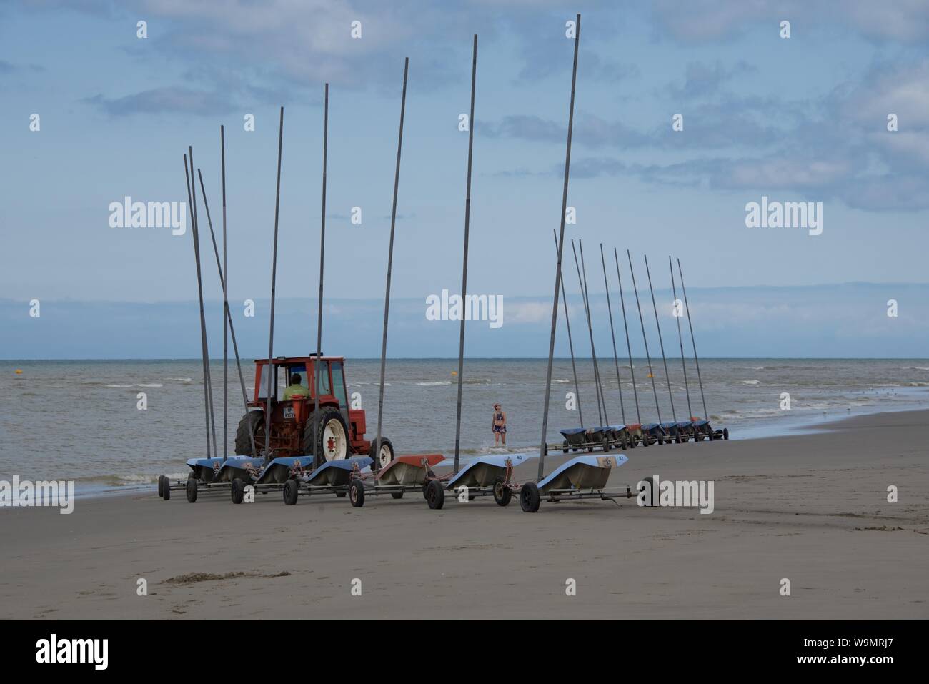 Un tracteur tirant 9 liée char à voiles, sans voiles, sur la plage en préparation à un concours Banque D'Images