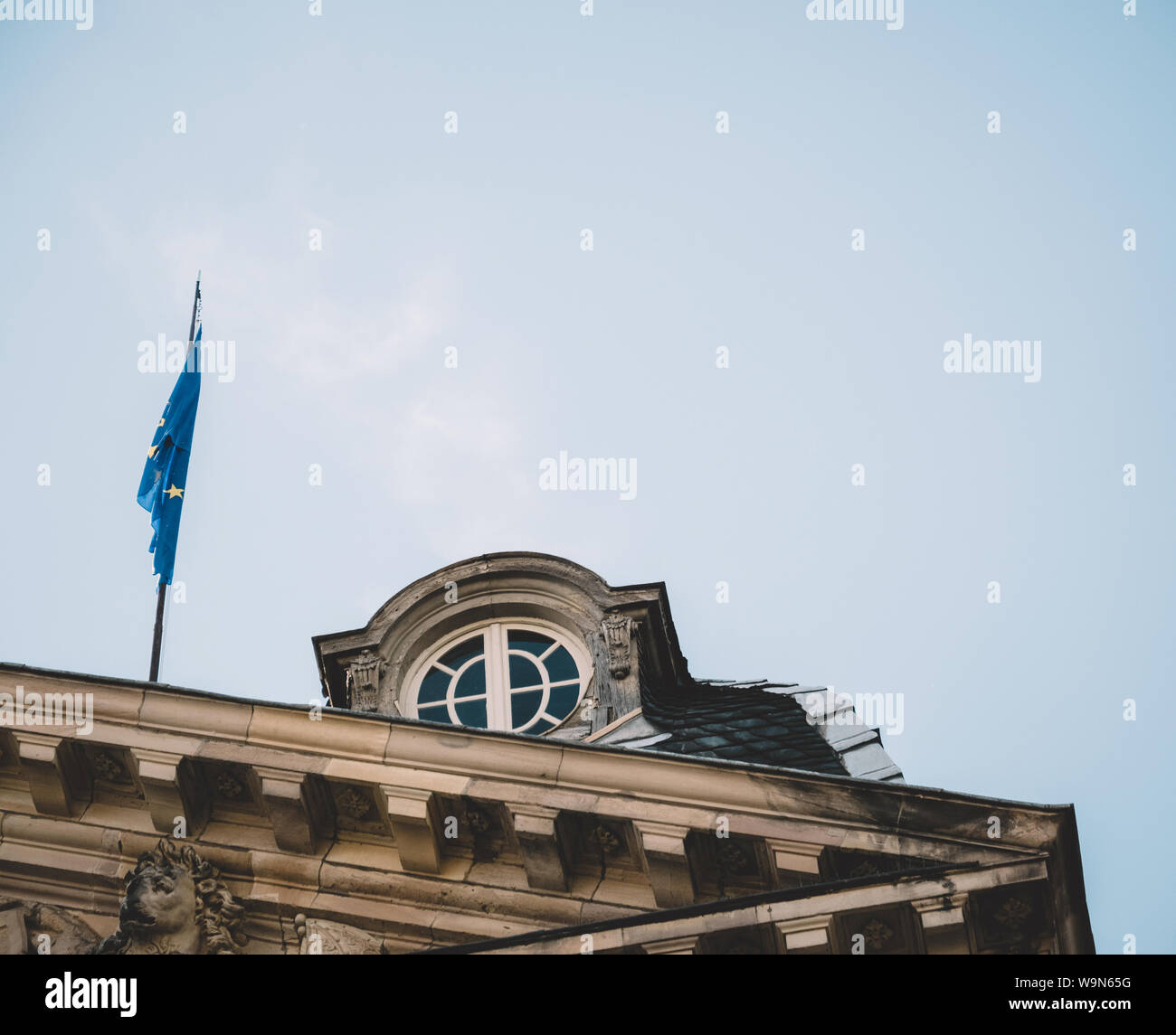 Vintage filtre plus de brandir le drapeau bleu de l'Union européenne  calmement sur le toit du Palais des Rohan à Strasbourg avec de belles  fenêtre ouvragée et ciel bleu clair Photo Stock -