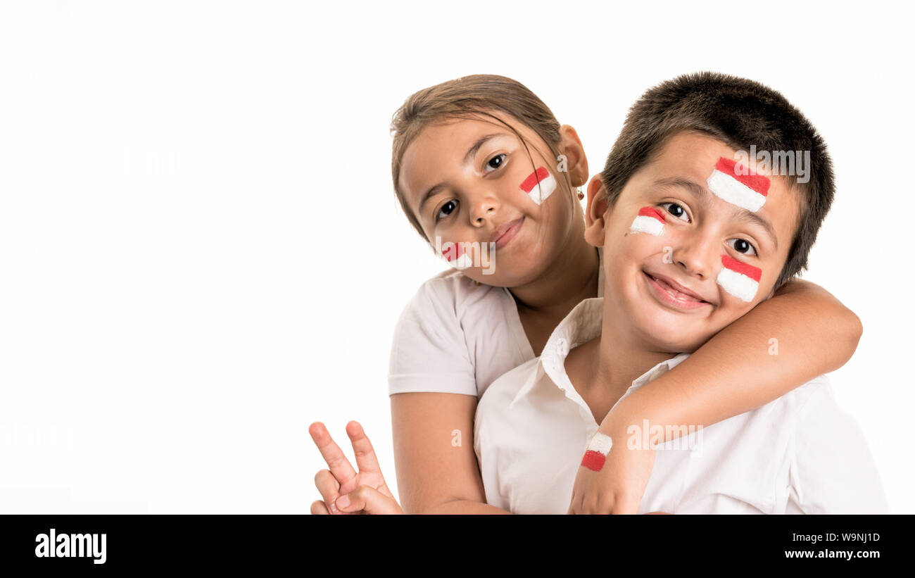 Jeune garçon et fille heureux ensemble tout en portant la peinture pour le visage de leur drapeau national, l'Indonésie - L'indépendance nationale, de l'image concept de vacances. Banque D'Images