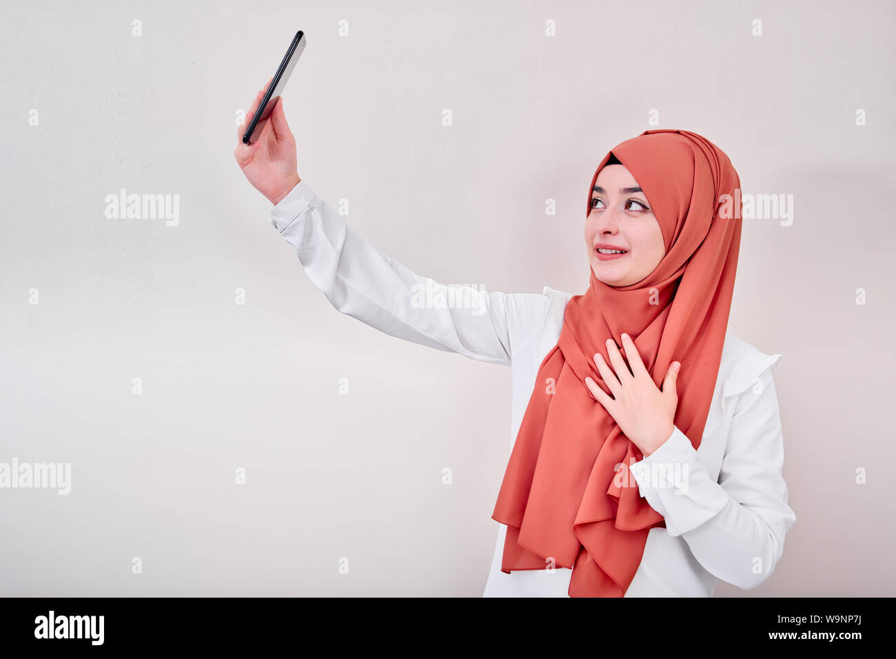 Femme musulmane en tenant, portrait de selfies hijab fille musulmane prendre une photo, le fond est isoalted. Banque D'Images