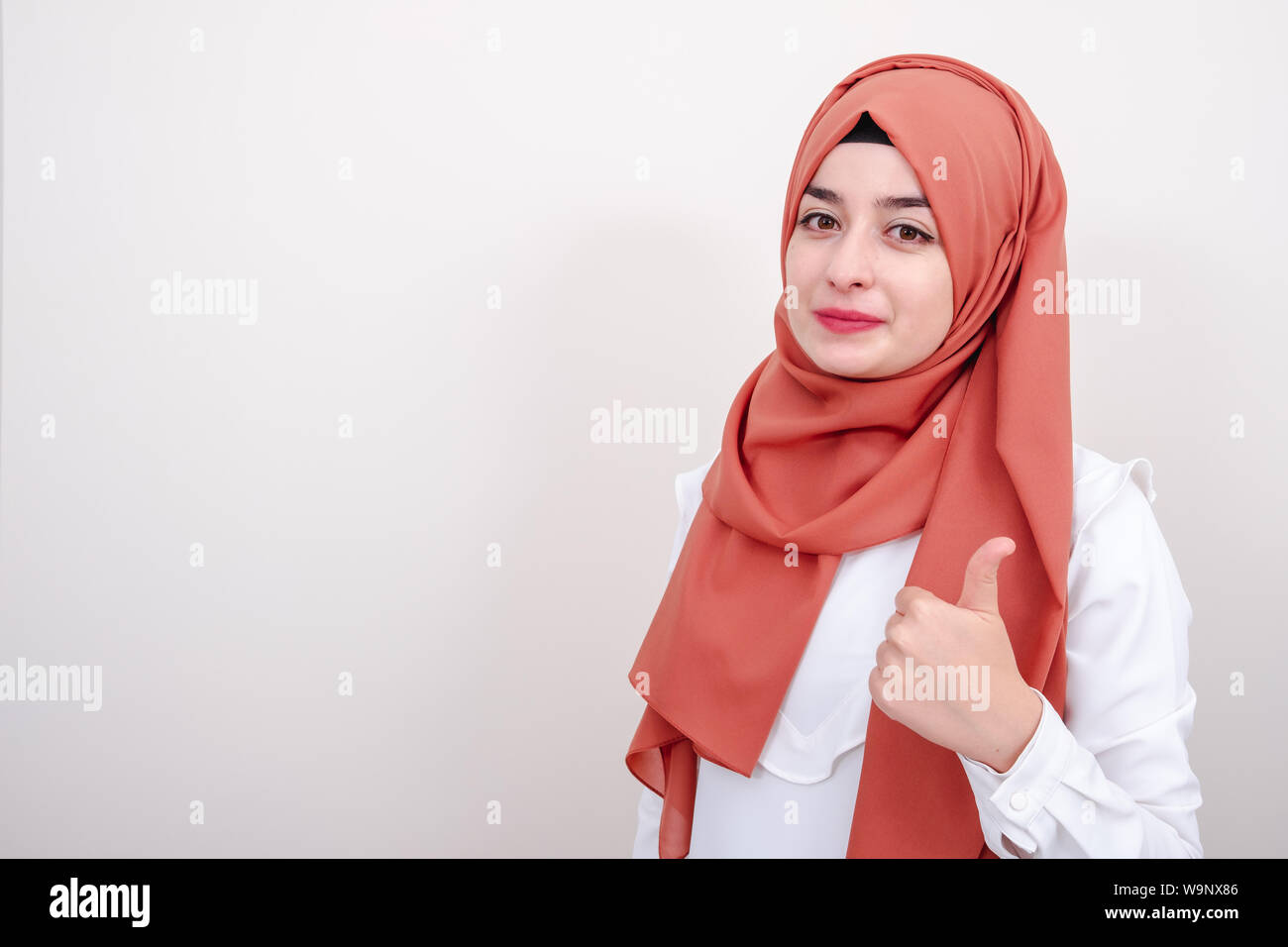 Hijab muslim woman showing Thumbs up geste avec la main. L'expression d'approbation à l'appareil photo Banque D'Images