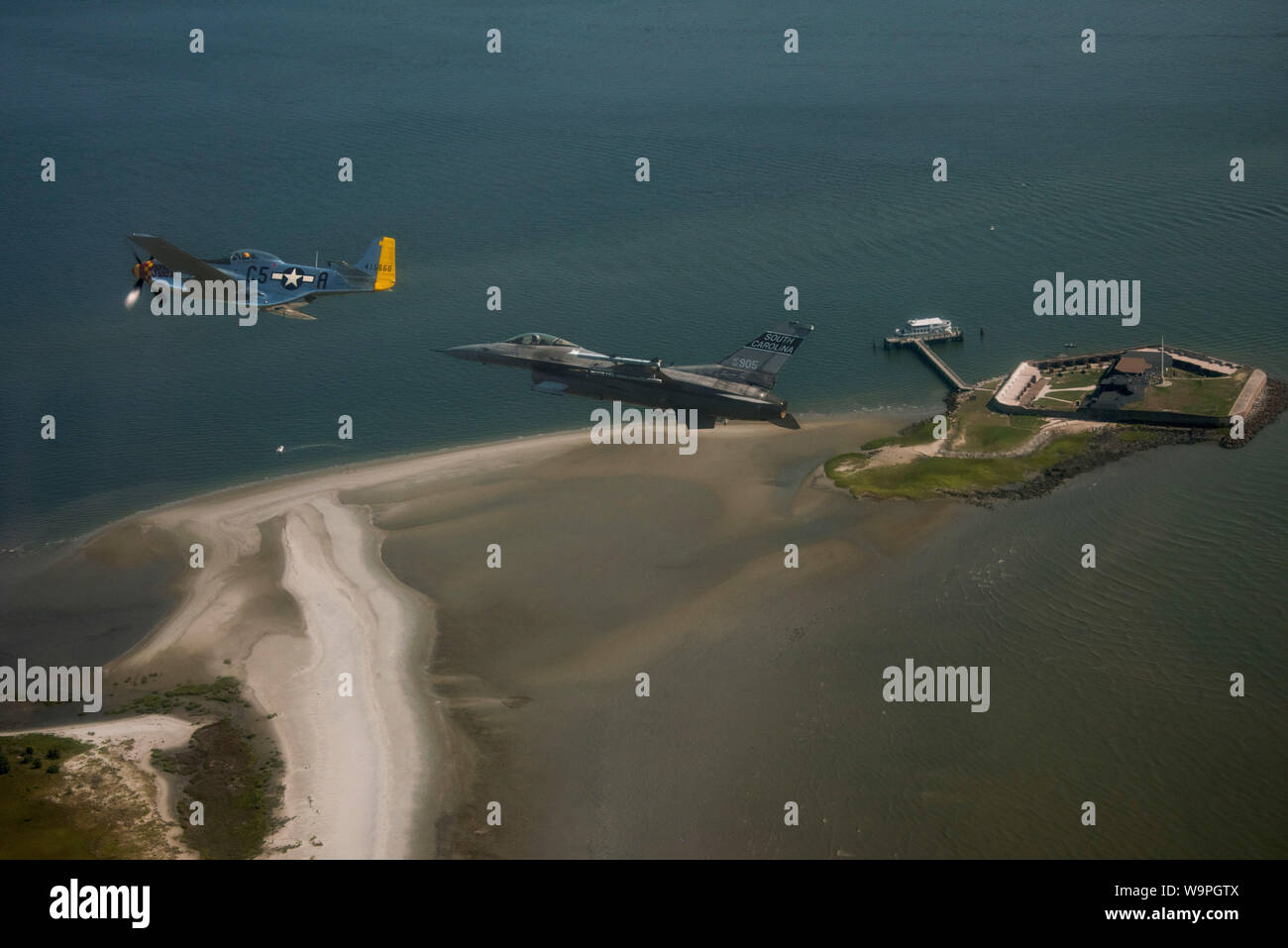 Caroline du Sud un Air National Guard F-16 Fighting Falcon fighter jet, affecté à la 169e Escadre de chasse, McEntire Joint National Guard Base, L.C. et une deuxième guerre mondiale P-51 Mustang s'associent pour célébrer leur histoire de l'aviation en volant ensemble près de South Carolina landmarks, Fort Sumter et USS Yorktown (CV 5), 10 août 2019. La FW 169 est fière de ses 70 ans et plus comme une seule unité de chasseur et son homonyme, Caroline du sud-américain héros de guerre révolutionnaire général Francis Fox "le marais" Marion. Le P-51 Mustang porte le nom de "Swamp Fox". Le P-51, détenu et exploité par R.T. Dickson, wa Banque D'Images