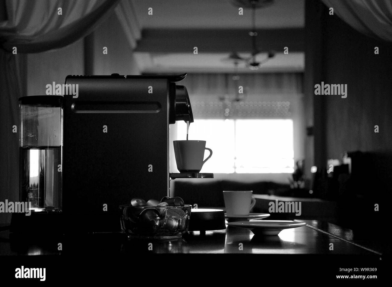 Machine à café expresso en silhouette, vue d'ensembles lors du remplissage de tasse à café. Banque D'Images