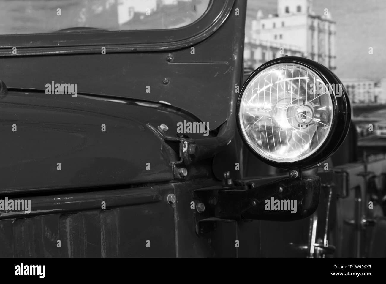 Détail d'un vintage army véhicule hors route, conçu comme une vieille photo ; projecteur contre un paysage urbain Banque D'Images