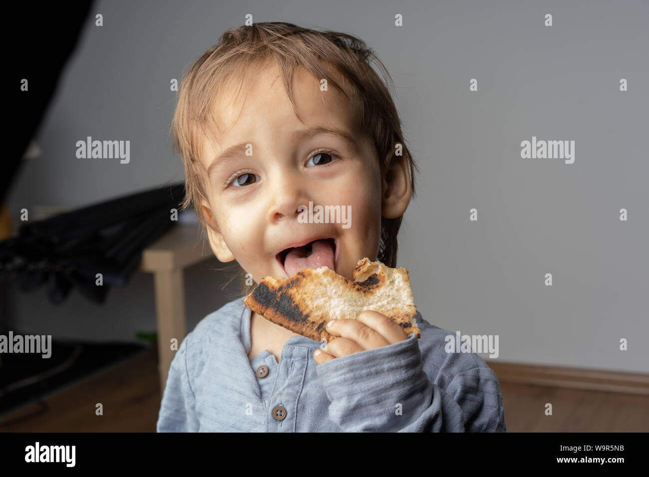 Portrait of happy joyeux beau petit garçon mange une délicieuse pizza. Le bonheur et la joie dans ses yeux. Super mignon petit garçon. Banque D'Images