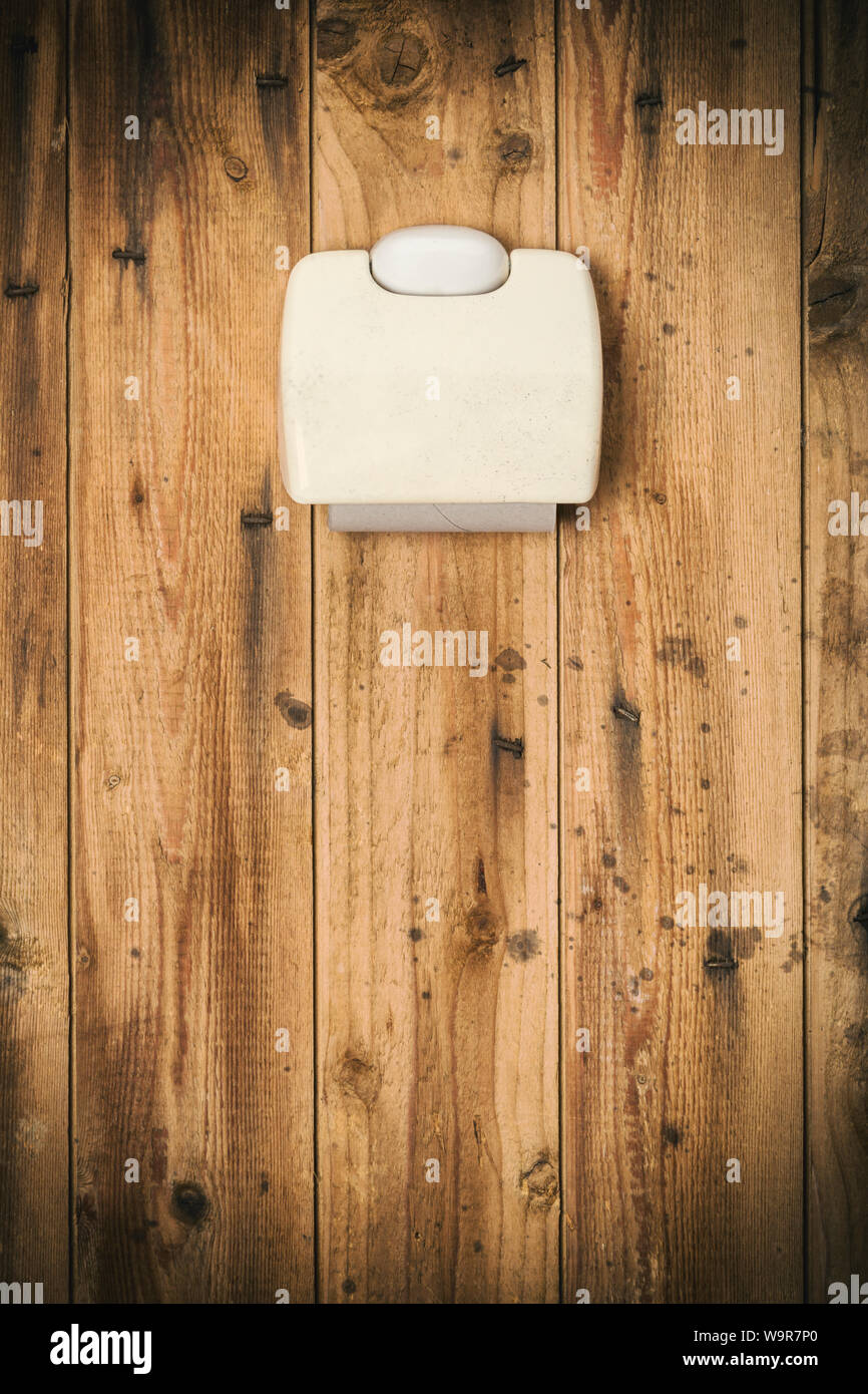 Concept de dégoût. Porte-papier toilette rouleau vide sur très sale outhouse wall Banque D'Images