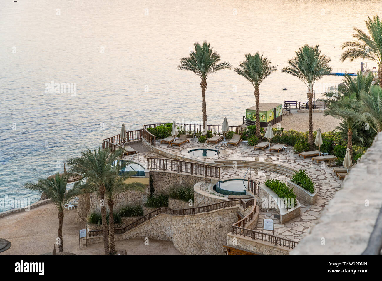 Sharm El Sheikh, Egypte - Mai 2019 : Belle plage ensoleillée et des parasols sur la côte de la mer Rouge dans la ville de Sharm El Sheikh, Egypte. Banque D'Images