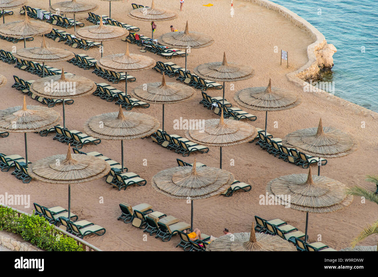 Sharm El Sheikh, Egypte - Mai 2019 : Belle plage ensoleillée et des parasols sur la côte de la mer Rouge dans la ville de Sharm El Sheikh, Egypte. Banque D'Images