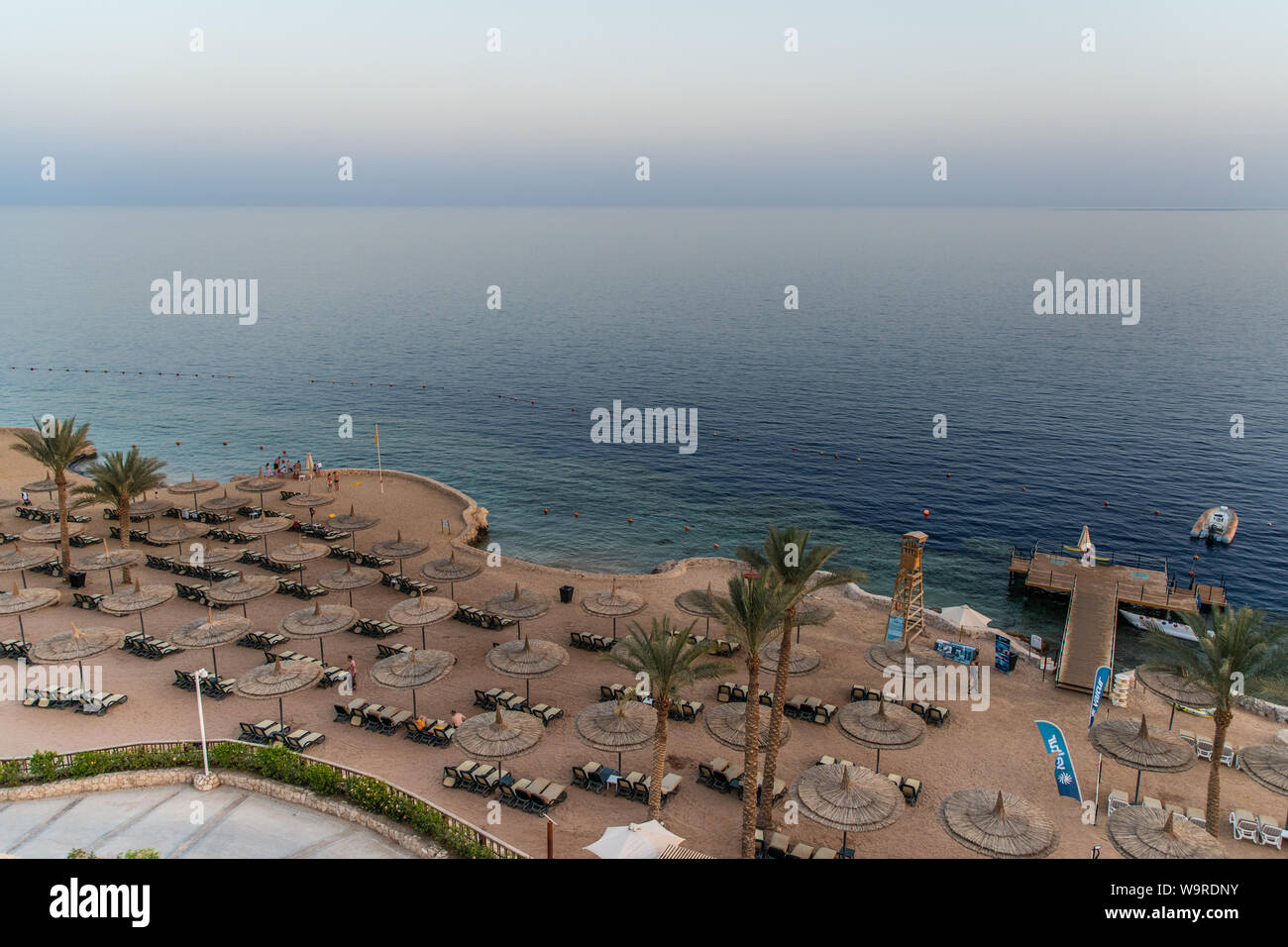 Sharm El Sheikh, Egypte - Mai 2019 : Belle plage ensoleillée et des parasols sur la côte de la mer Rouge dans la ville de Sharm El Sheikh, Egypte. Banque D'Images