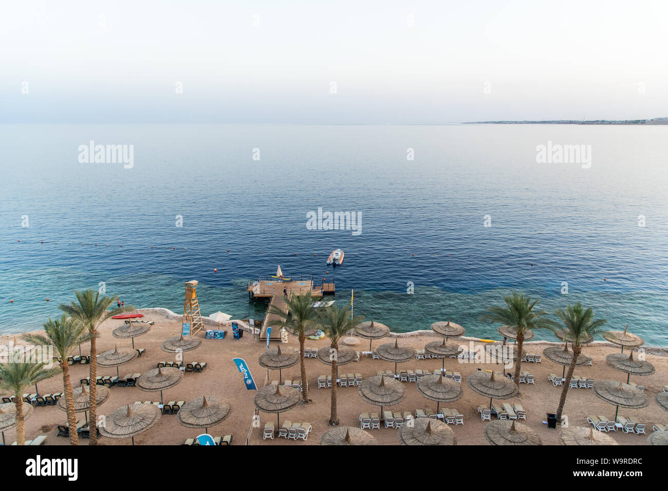 Sharm El Sheikh, Egypte - Mai 2019 : Belle plage ensoleillée et des parasols sur la côte de la mer Rouge dans la ville de Sharm El Sheikh, Egypte. Banque D'Images