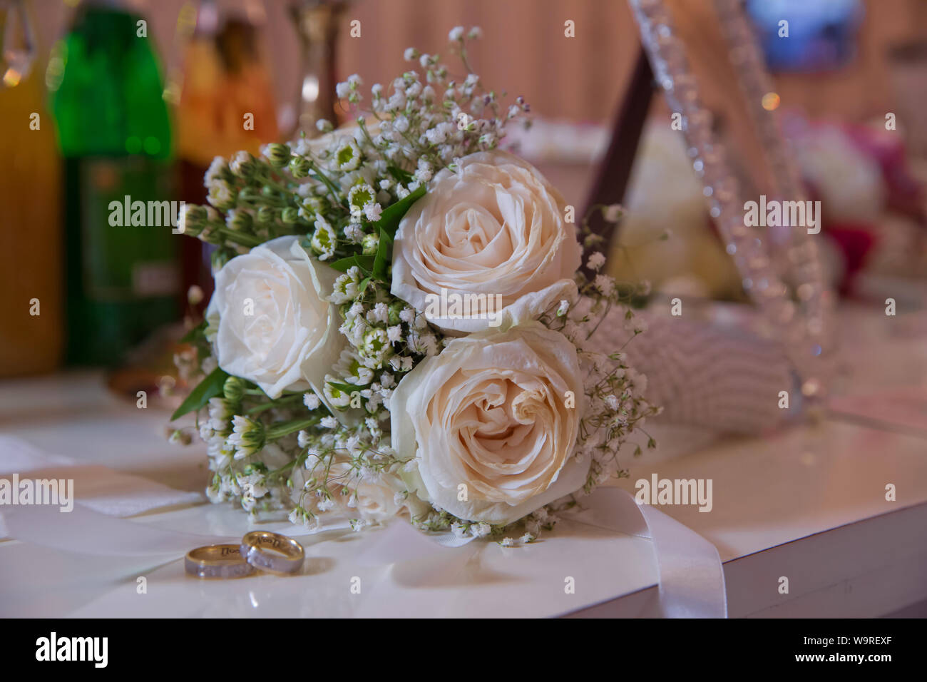 Fleur de mariage blanc élégant anneaux situés à l'avant du bouquet de mariage . Plates-formes de mariage devant un bouquet de mariage. Profondeur de champ Banque D'Images