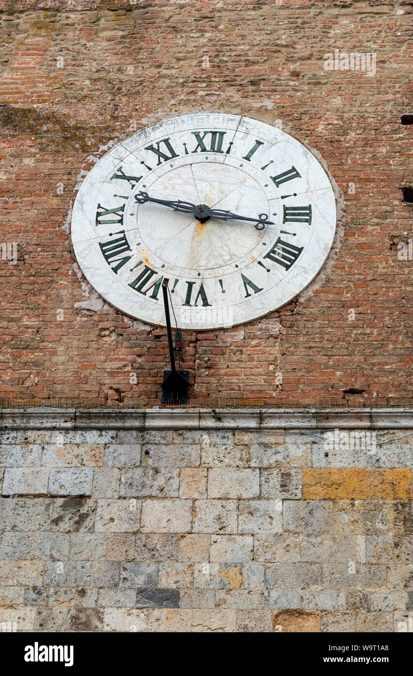 Vieux réveil sur mur de brique extérieur de Santa Maria della Scala, Sienne Banque D'Images