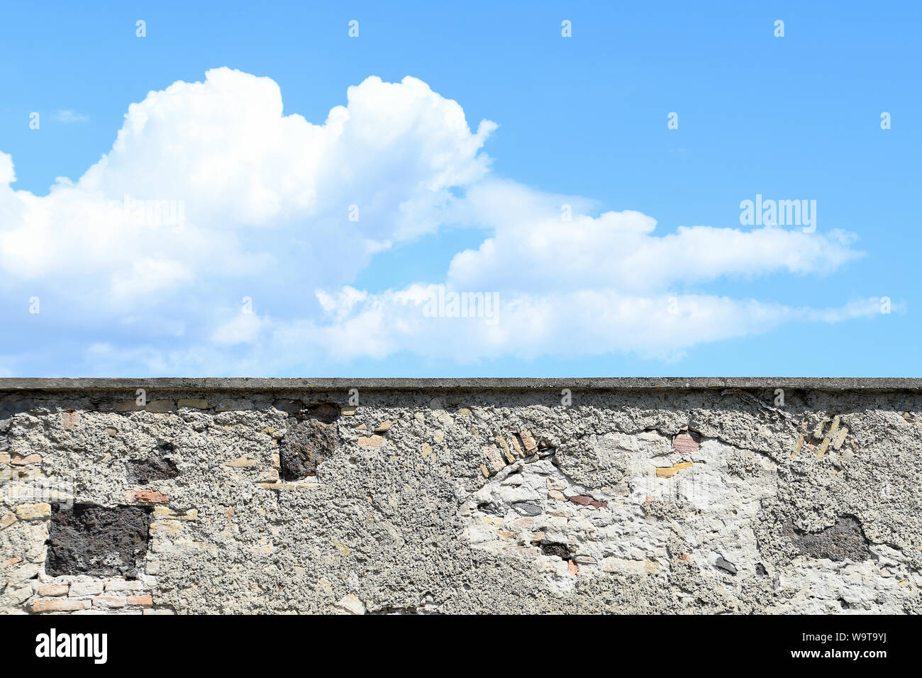 Mur de château en pierre patiné avec ciel bleu et de nuages Banque D'Images Mur de château en pierre patiné avec ciel bleu et de nuages Banque D'Images