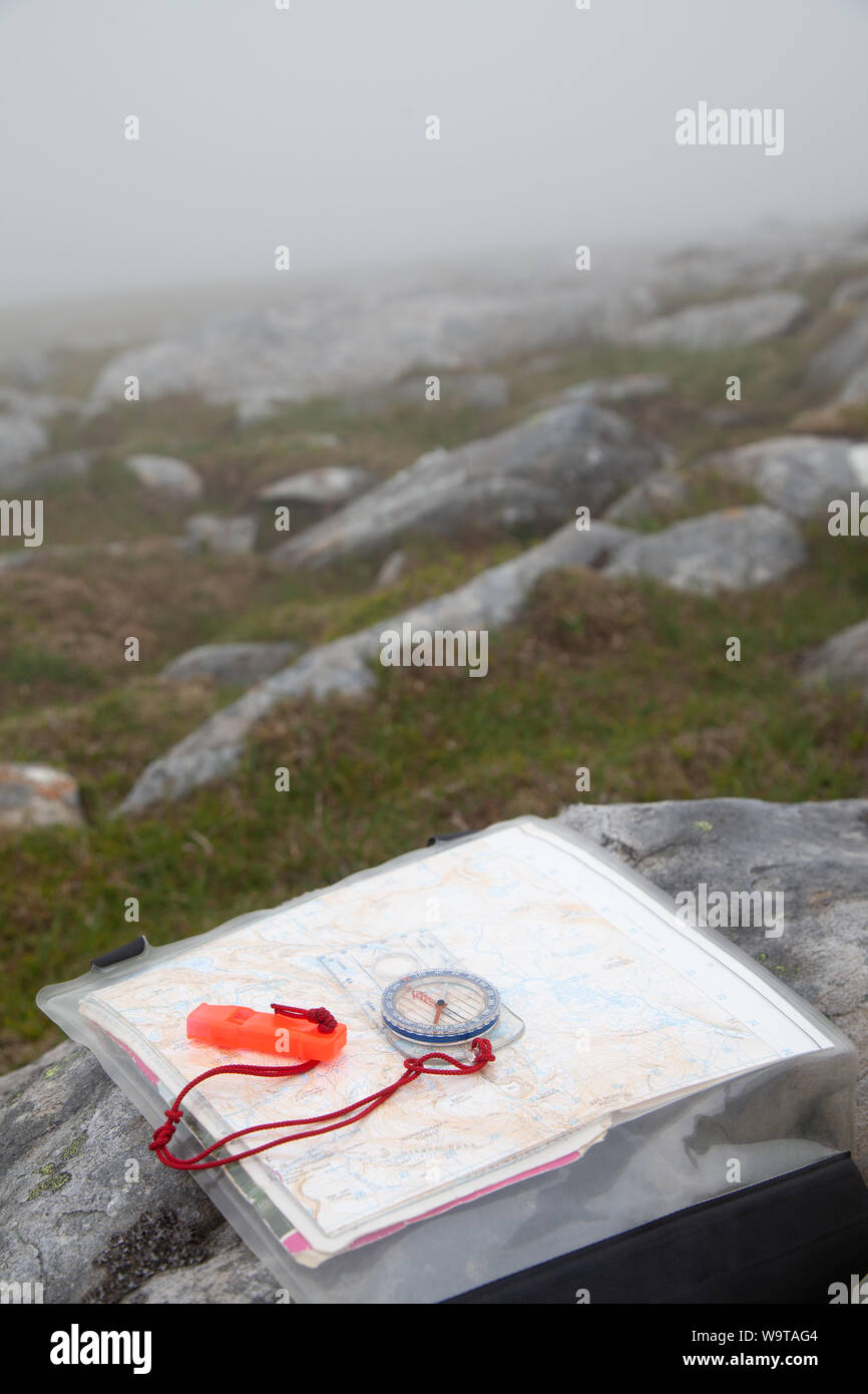Plan de compas de navigation avec sifflet et carte sur une colline dans le brouillard. Banque D'Images