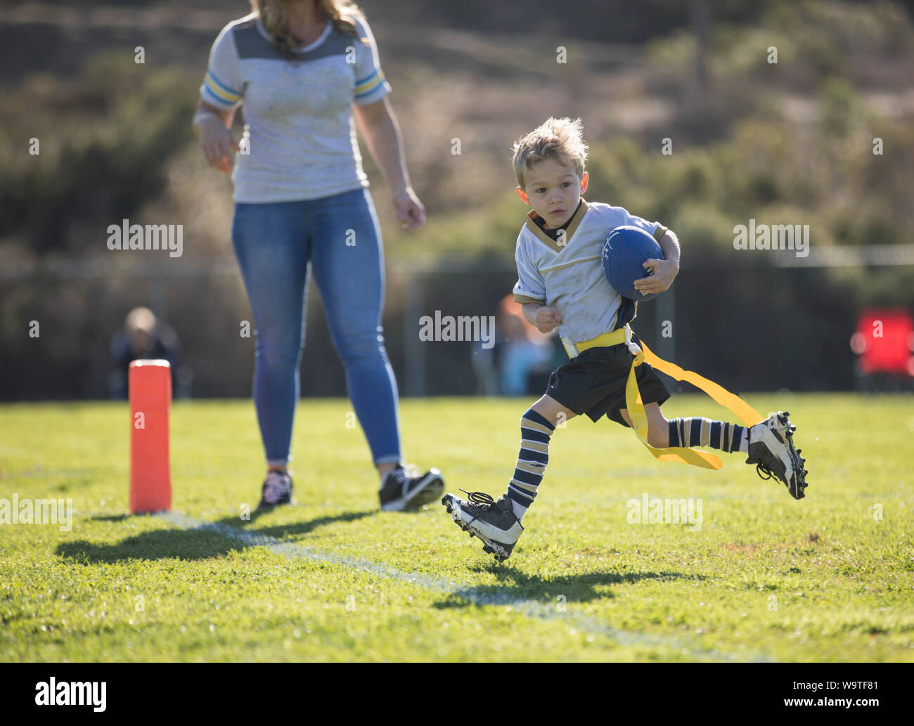 Mère regardant son fils marquer un touchdown dans le flag-football, California, United States Banque D'Images