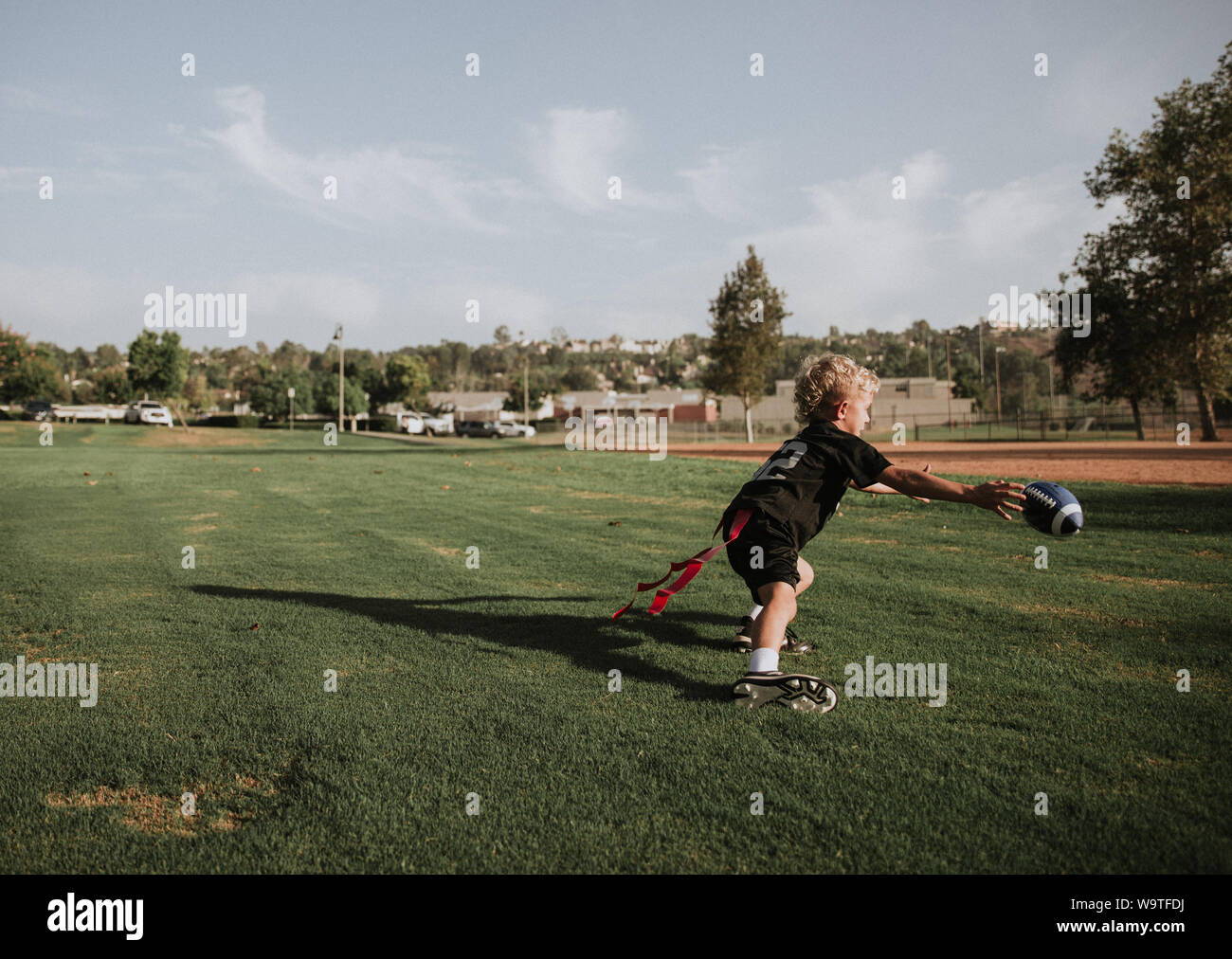 Boy playing football drapeau attraper une balle, California, United States Banque D'Images