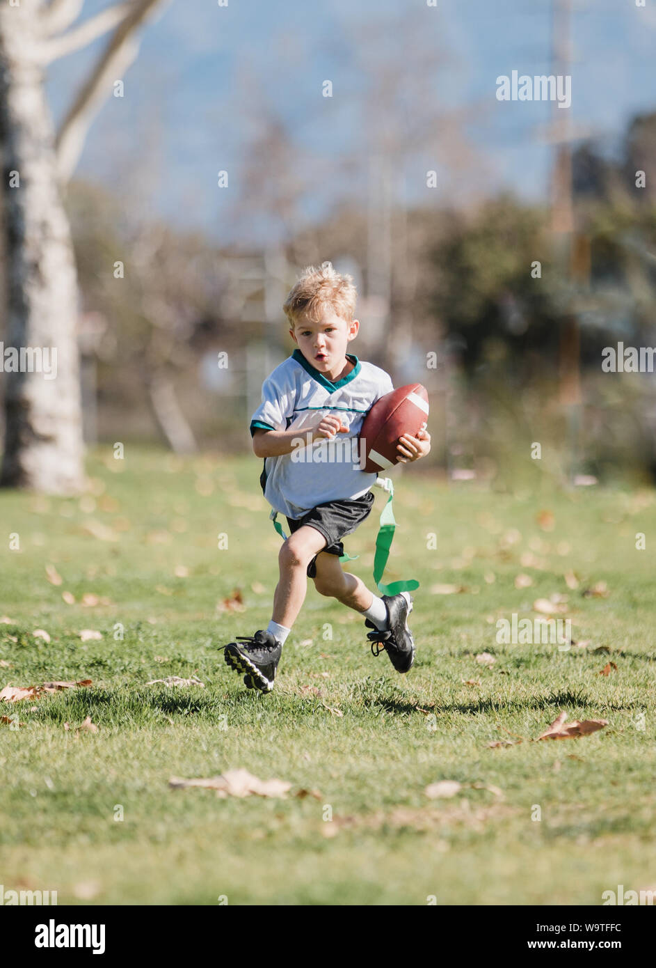 Boy playing football drapeau, California, United States Banque D'Images