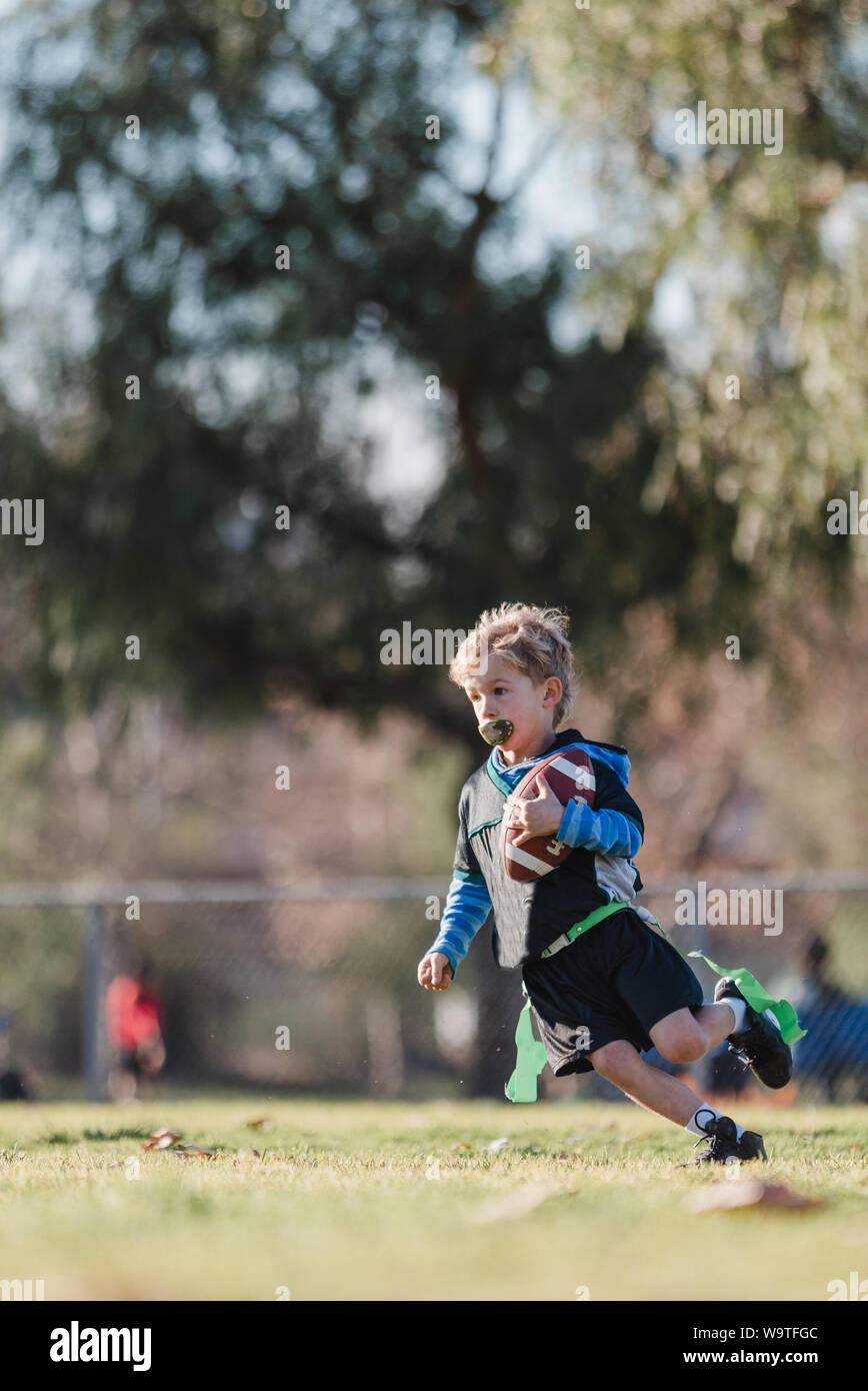Boy playing football drapeau, California, United States Banque D'Images