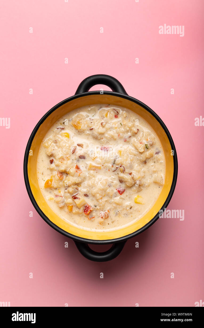 Avec Chaudrée de maïs doux, crevettes et bacon dans un bol noir sur fond rose Vue de dessus Banque D'Images