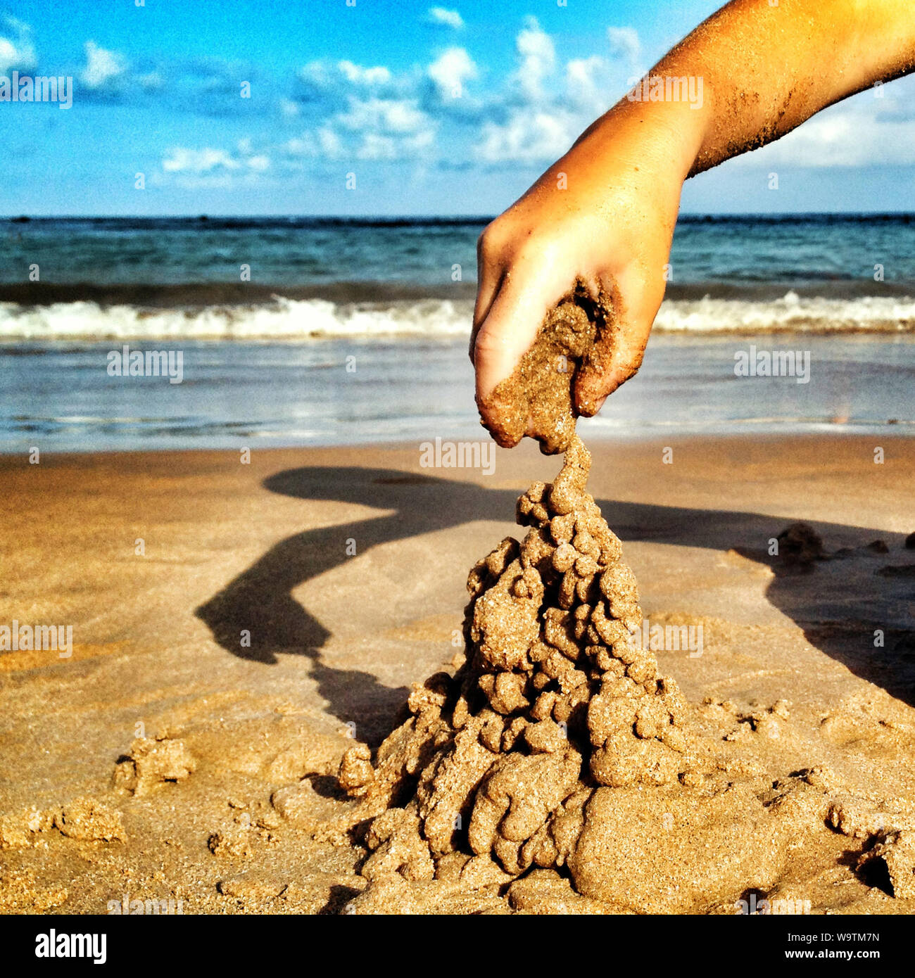 Garçon jouant avec le sable sur la plage, Espagne Banque D'Images