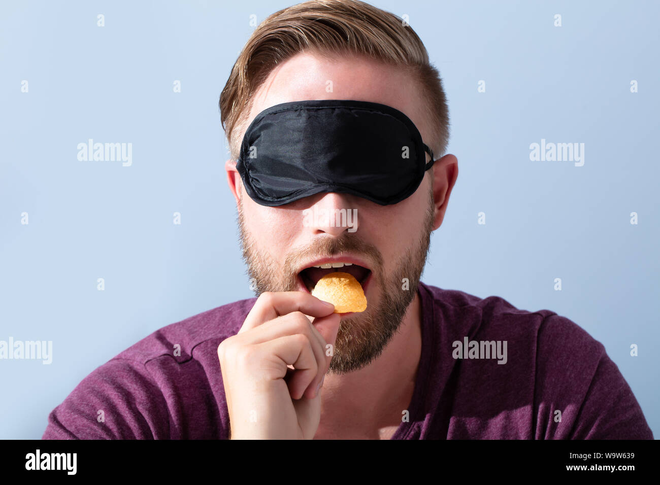 Portrait de jeune homme, les yeux bandés, nourriture d'échantillon Banque D'Images