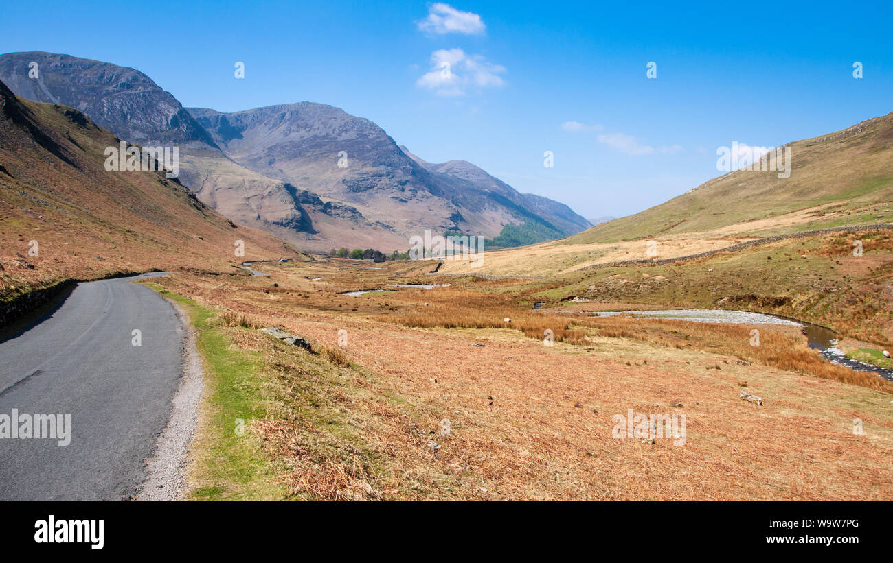 Un étroit chemin de campagne serpente à travers la vallée de Honister passe sous les montagnes de l'Angleterre de la Lake District. Banque D'Images