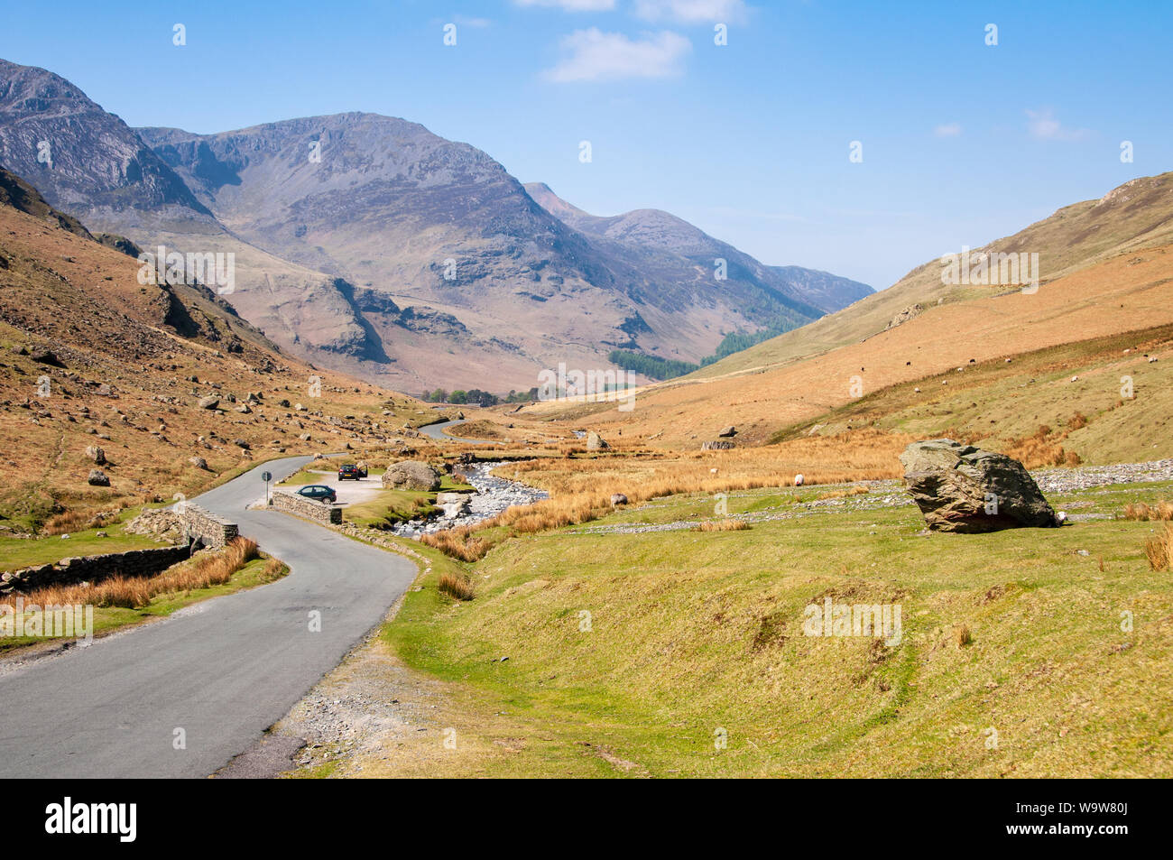 Un étroit chemin de campagne serpente à travers la vallée de Honister passe sous les montagnes de l'Angleterre de la Lake District. Banque D'Images