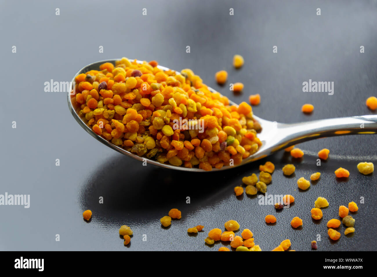 Le pollen des fleurs de la cuillère renversé sur la table sombre arrière-plan. Banque D'Images