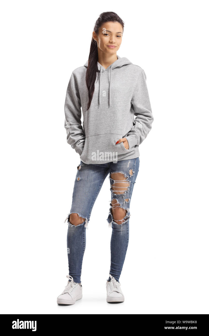 Portrait d'une jeune femme avec des jeans déchirés et un hoodie posant isolé sur fond blanc Banque D'Images