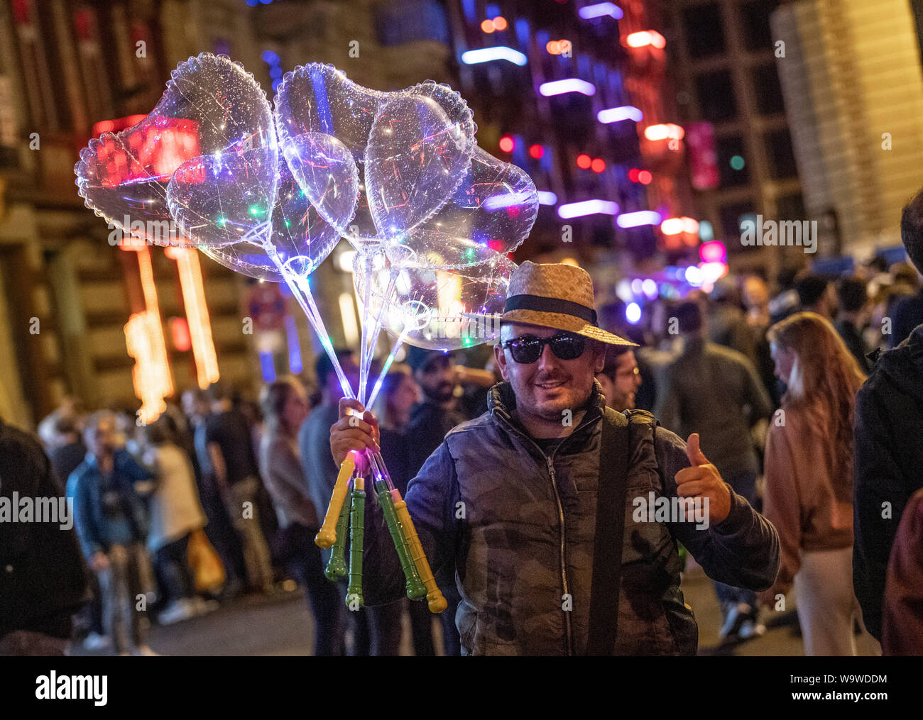 15 août 2019, Hessen, Frankfurt/Main : un homme vend des ballons en forme de cœur sur station trimestre nuit. Chaque année, les saucisses de célébrer la gare, avec le festival de rue. (Dpa "Frankfurt célèbre gare trimestre avec la grand rue festival') Photo : Boris Roessler/dpa Banque D'Images