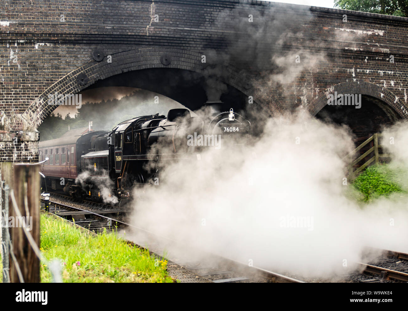 Aucune locomotive 76084 class 4MT, il roule sous le pont à Weybourne gare avec un râteau de calèches Banque D'Images