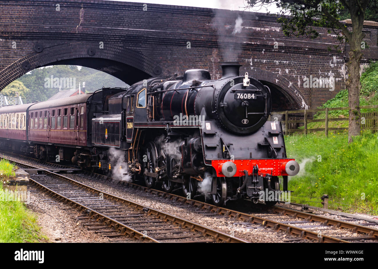 Aucune locomotive 76084 class 4MT, il roule sous le pont à Weybourne gare avec un râteau de calèches Banque D'Images