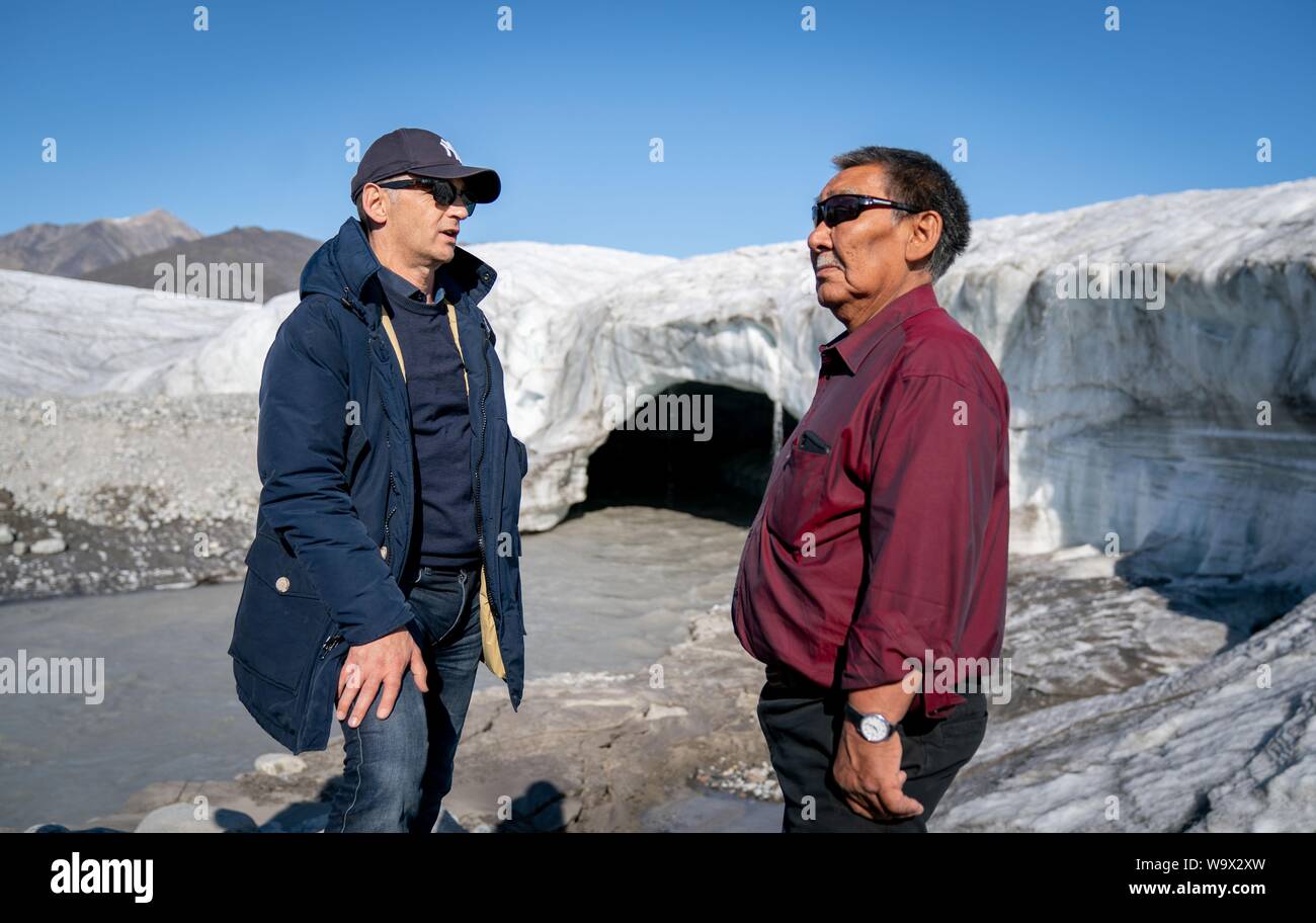 Pond Inlet, Canada. Août 15, 2019. Le ministre fédéral des affaires étrangères, Heiko Maas (l, SPD) parle à un garde forestier du parc sur une randonnée glaciaire près de Pond Inlet, dans l'Arctique canadien. Le petit village Inuit avec seulement 1 300 habitants vont faire face aux conséquences du changement climatique, qui n'est nulle part plus visible que dans l'Arctique. Credit : Kay Nietfeld/dpa/Alamy Live News Banque D'Images