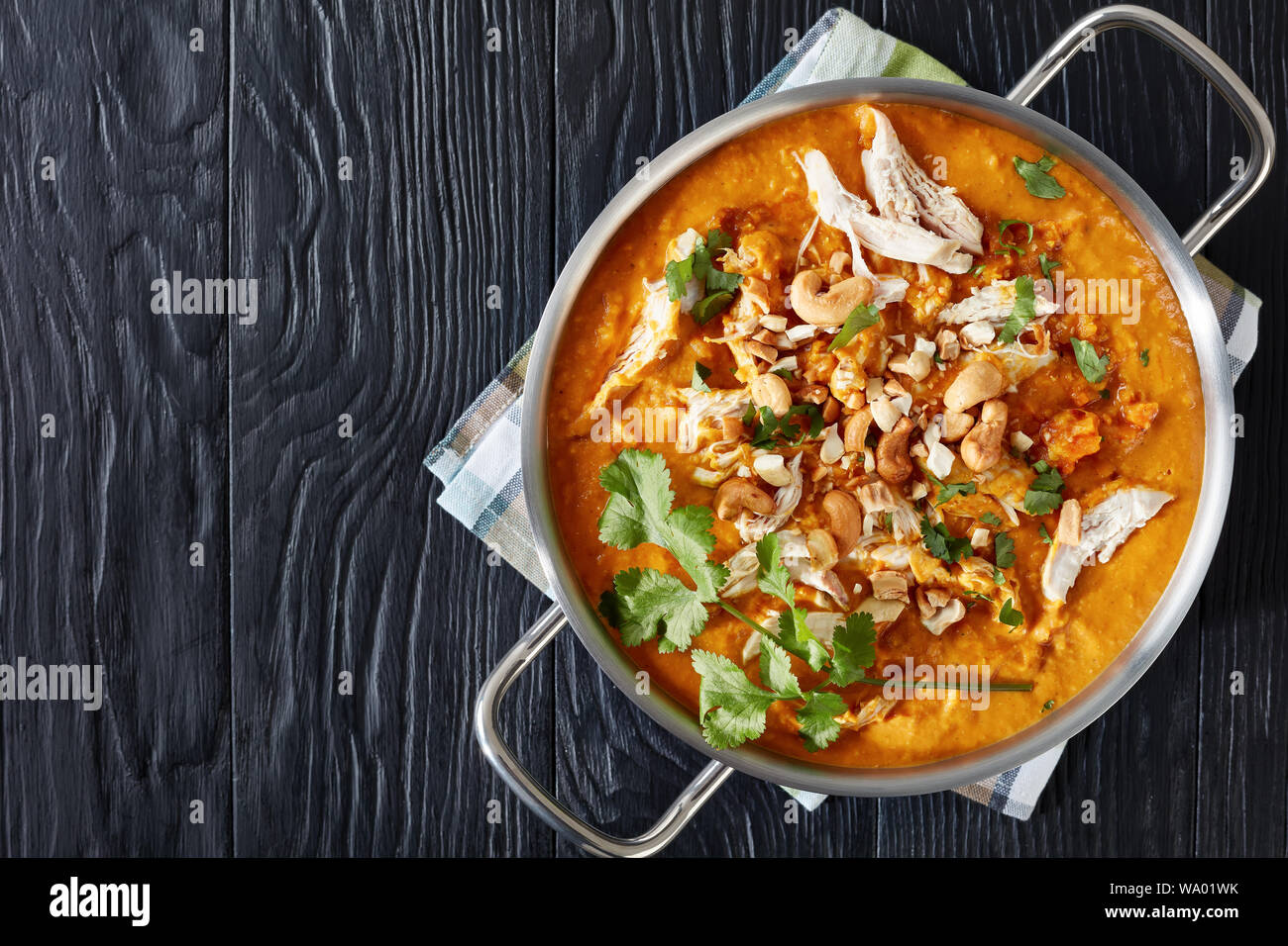 Soupe Mulligatawny indien parfumé est épicé avec curry et crème à base de lentilles rouges, les carottes, les pommes et le lait de coco, servi dans une casserole en métal Banque D'Images