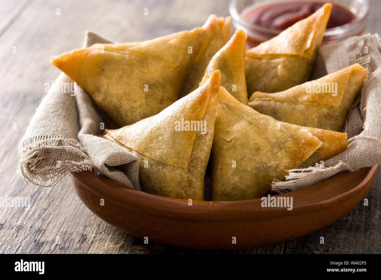 Samsa ou samossas à la viande et les légumes dans un bol sur la table en bois. La cuisine indienne traditionnelle. Banque D'Images