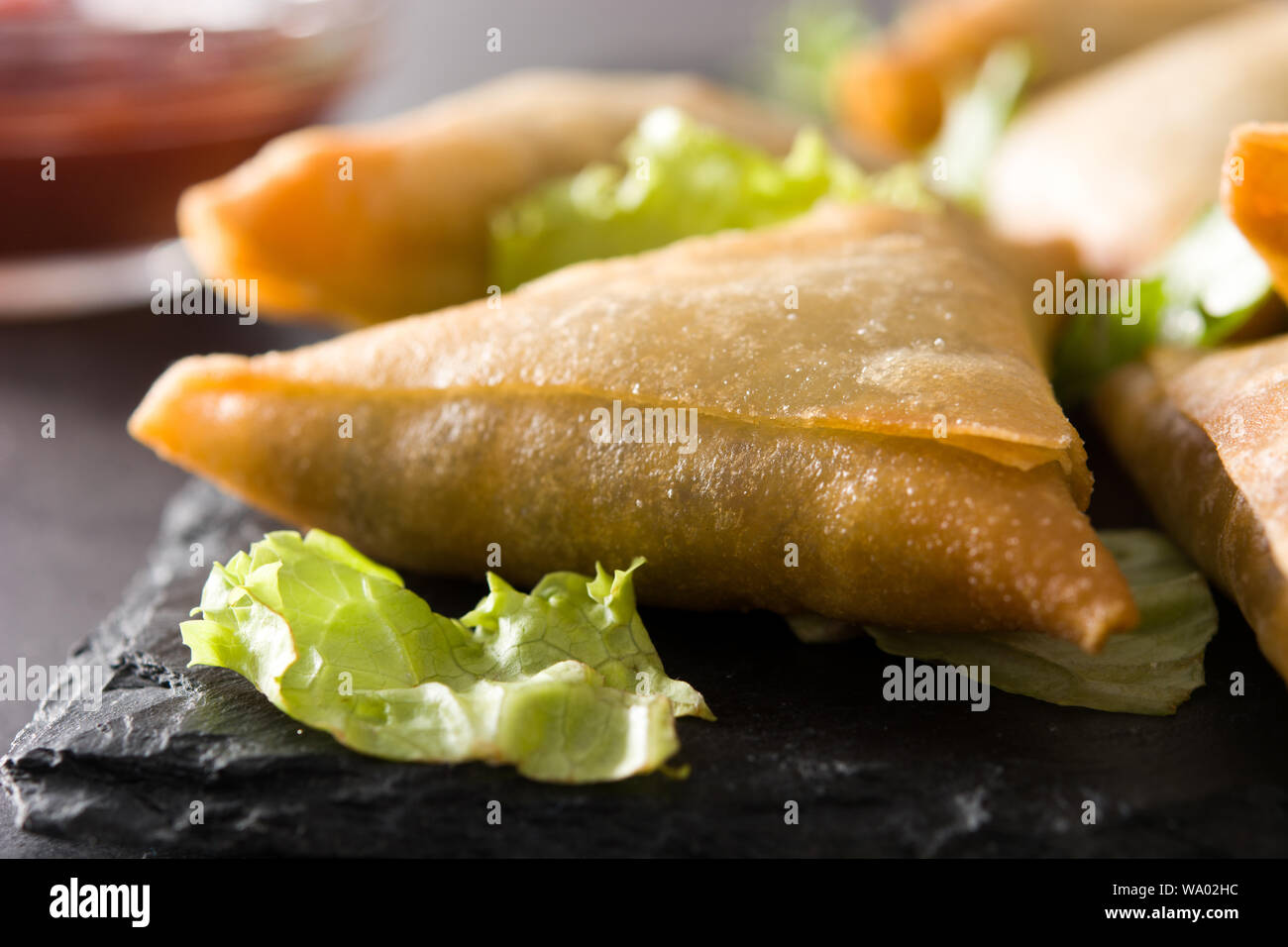 Samsa ou samossas à la viande et légumes sur fond noir. La cuisine indienne traditionnelle. Close up Banque D'Images