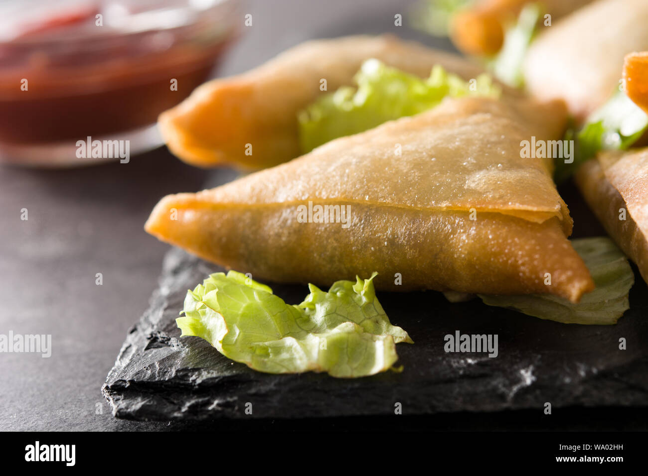 Samsa ou samossas à la viande et légumes sur fond noir. La cuisine indienne traditionnelle. Close up Banque D'Images