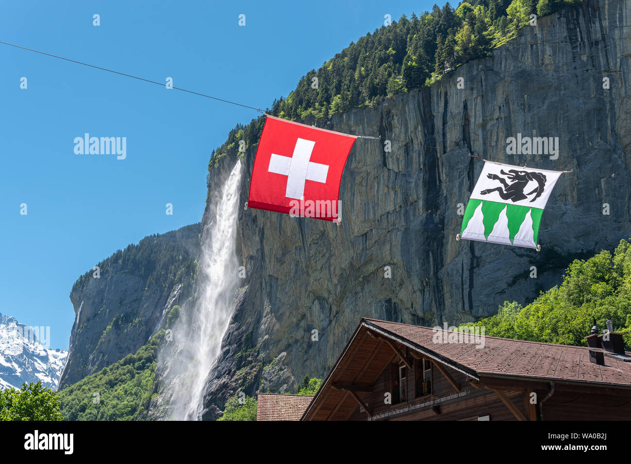 Drapeau suisse et drapeau municipal de Lauterbrunnen en avant du Staubbach, Grindelwald, Oberland Bernois, Suisse, Europe Banque D'Images
