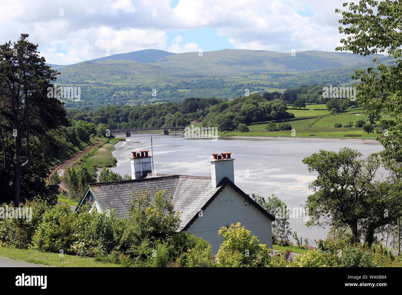 Maison Sur les rives de la rivière Conwy avec la voie de chemin de fer de la vallée de Conwy, au Pays de Galles Banque D'Images