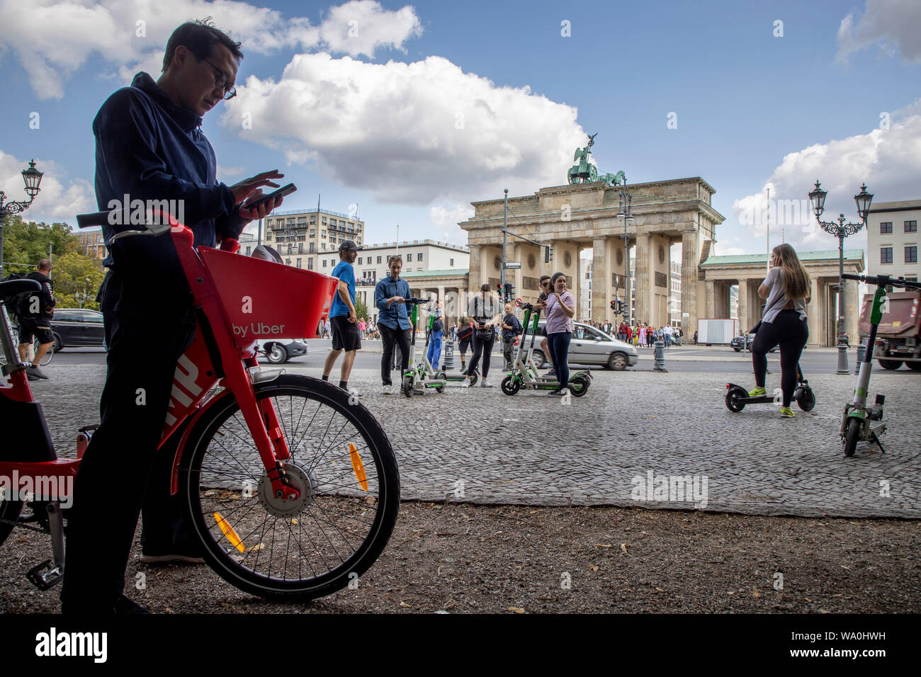 Homme avec location e-bike de Uber, scooter électrique, scooter électrique, scooter électrique, en face de la porte de Brandebourg à Berlin, Banque D'Images