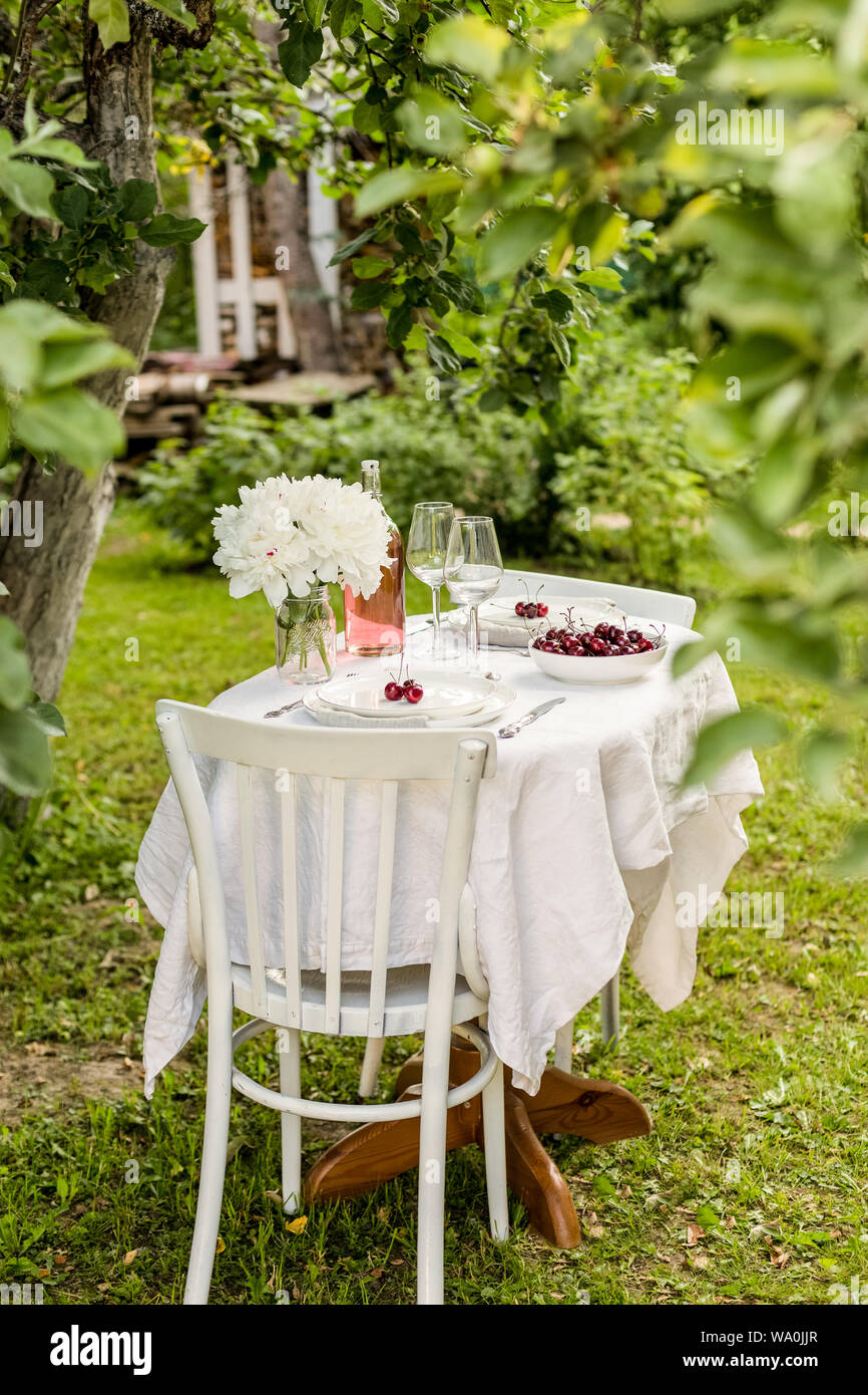 Set de table à l'extérieur de fleurs et de deux assiettes de service avec sweet cherry Banque D'Images Set de table à l'extérieur de fleurs et de deux assiettes de service avec sweet cherry Banque D'Images