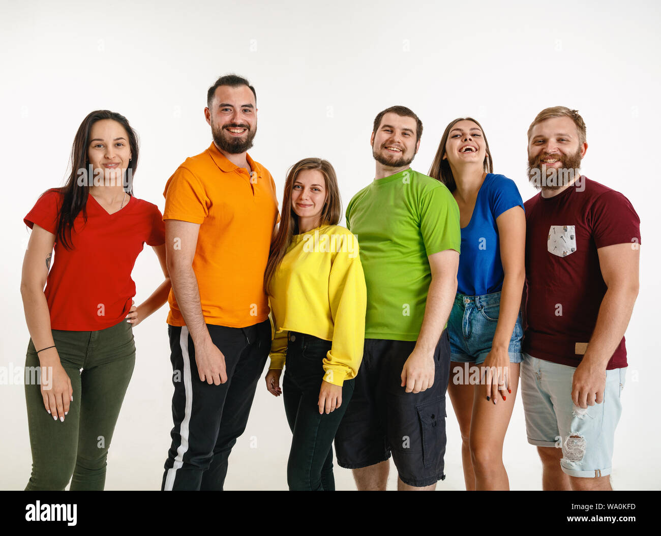 Jeune homme et femme portée au drapeau LGBT couleurs sur fond blanc. Modèles de race blanche dans des chemises. L'air heureux, souriant et serrant. La fierté LGBT, des droits de l'homme et choix concept. Banque D'Images